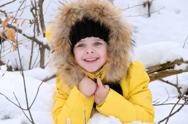 Kleines Mädchen spielt im Winter im Schnee. — Stockfoto