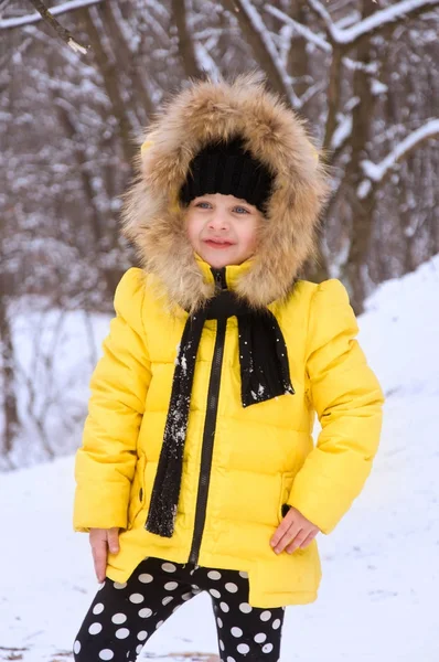 Маленькая девочка играет в снегу зимой . — стоковое фото