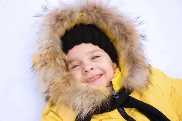 Kleines Mädchen spielt im Winter im Schnee. — Stockfoto