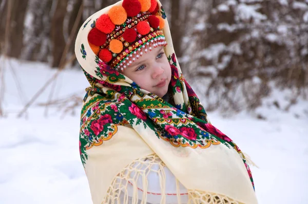 Kleines Mädchen im Winterwald. gekleidet in die ukrainische Nationalflagge — Stockfoto