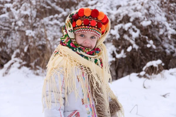 Liten flicka i vinter skog. klädd i ukrainska nationella Stockbild