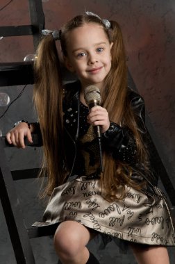 küçük kız elinde mikrofon ile. Genç yıldız. sta çocuklara