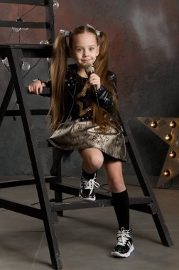 küçük kız elinde mikrofon ile. Genç yıldız.