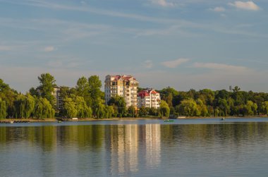 Güzel ev ayakta yakın zaman akşam kırsal kesimde göl.