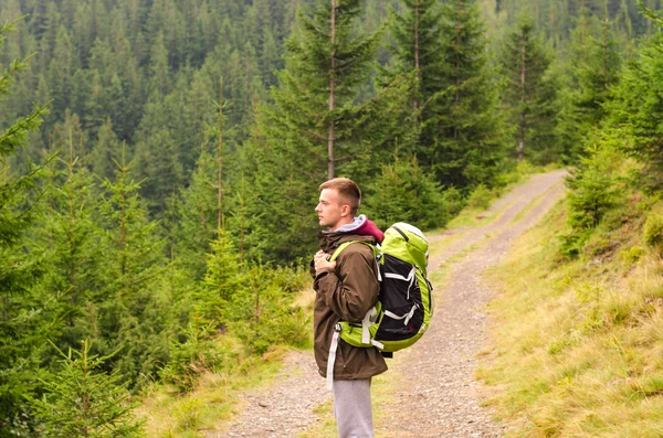 Outdoor Portret van een jonge man die wandelen op de bergen, lacht gelukkig portret van toeristische male.extreme sport, sportuitrusting, reistas, Kaukasische mannelijke wandelaar wandelen in het bos. — Stockfoto