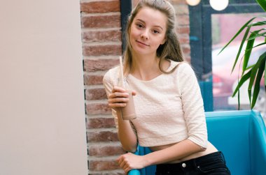 Detoks suyu ve Smoothies sağlıklı beslenmesi için. Güzel gülümseyen kadın oturuyor içinde kafe ile taze Detoks suyu içinde şişe ve içme, masada bardaklarda sebze güler yüzlü içer. Kilo Verme Diyet 