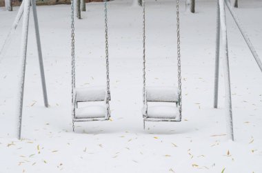 karla kaplı çocuksuz bir kar fırtınası içinde Çocuk salıncaklar.