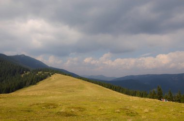 Dağlardaki yaz manzarası ve bulutlu koyu mavi gökyüzü..