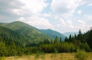 Dağlardaki yaz manzarası ve bulutlu koyu mavi gökyüzü..