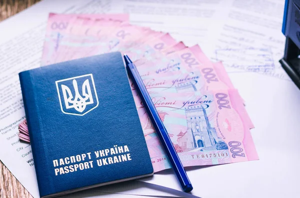 Международный паспорт гражданина Украины с гривнами на бумажном фоне. Украинские деньги, документы, печать и паспорт . — стоковое фото