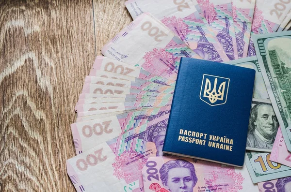 Международный паспорт Украины с гривнами на фоне долларов США . — стоковое фото