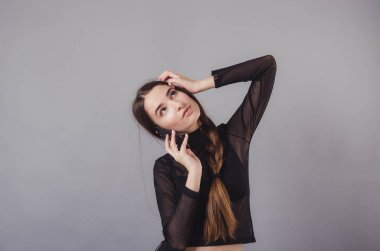 Nötr gri bir arka plan üzerinde izole bir genç çekici kız kullanma smartphone portresi.