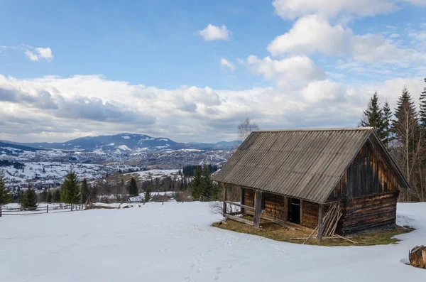 雪に覆われた山の古い老朽化した木造建築物. — ストック写真