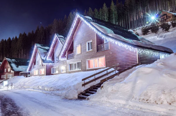 Rangée de maisons en bois dans une rue enneigée en hiver la nuit — Photo