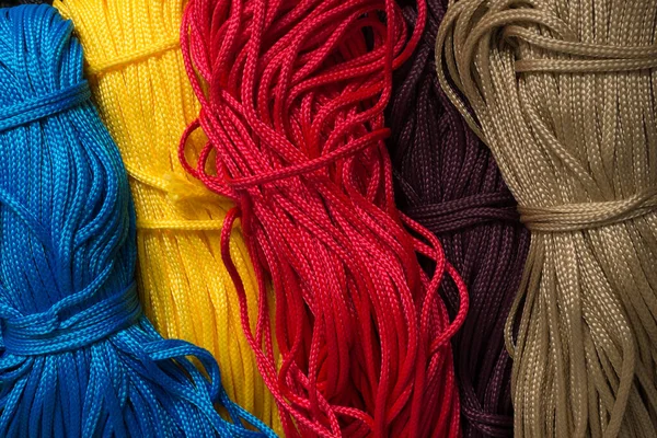 clothesline background. multi-colored ropes on a gray background. skein of thread