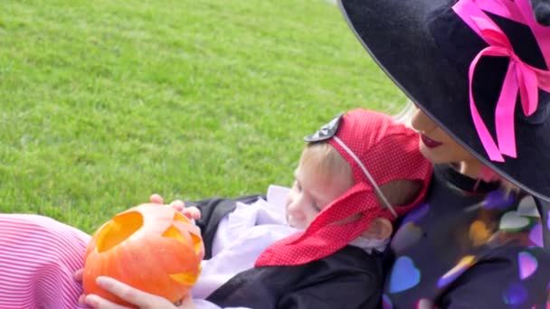 Mutter und Sohn in Halloween-Kostümen amüsieren sich auf Halloween-Party mit Jack-Laternen-Kürbis — Stockvideo