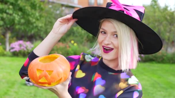 Schöne Hexe lächelnd und hängende Jack Laterne auf Halloween-Party — Stockvideo