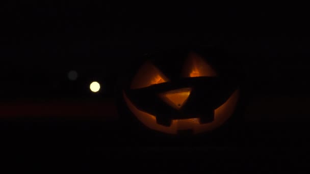 Jack o'lantern at empty road with red light — Stock video