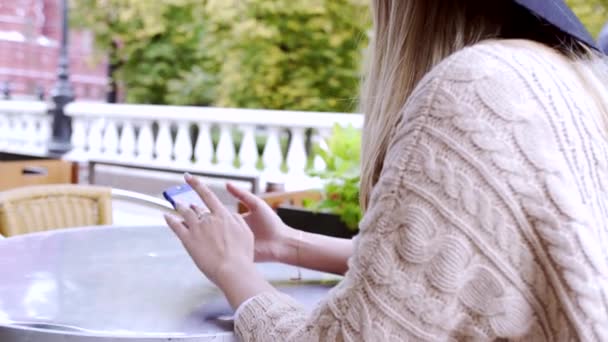 Mujer joven escribiendo mensaje en el teléfono en la mesa de la cafetería de Moscú — Vídeo de stock