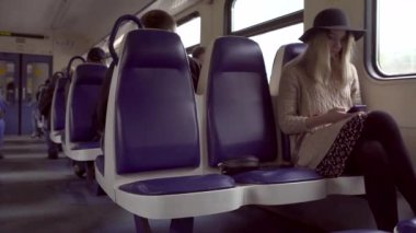 Müzik dinleme ve elektrikli tren telefonunda mesaj yazarak genç hippi kız