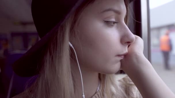 Tired teen girl portrait looking outside through train window — Stock Video