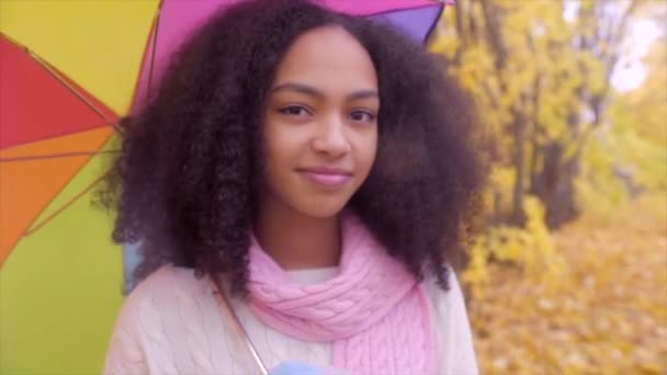 Cute teen girl with colour umbrella in autumn park — Stock Video