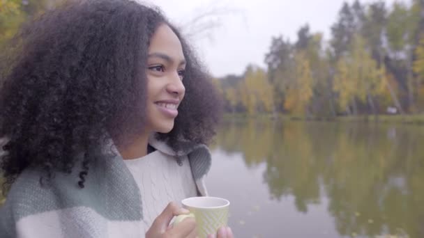 Bonito preto menina embrulhando-se no lã xadrez e beber Quente chá — Vídeo de Stock