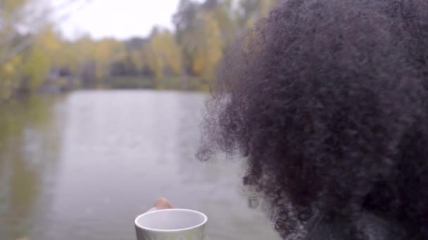 Schattig zwarte meisje zichzelf verpakken in wollen plaid en het drinken van hete thee — Stockvideo