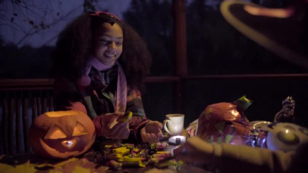 Leuk zwart meisje in de duivel masker beangstigend haar vriend op Halloween nacht — Stockvideo