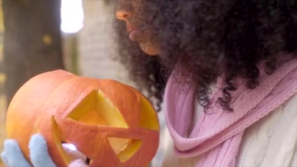 Schattig meisje lacht om Jack olantern — Stockvideo