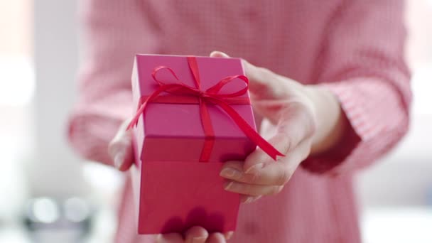 Womans hand opening red gift box with red ribbon — Stock Video