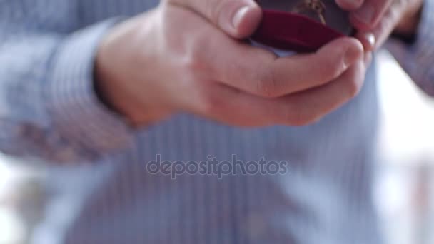 Hombre sosteniendo caja de regalo con anillo de compromiso en sus manos — Vídeo de stock