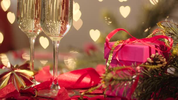 Copas llenas de champán y regalo de Navidad con rama de abeto decorada — Vídeos de Stock