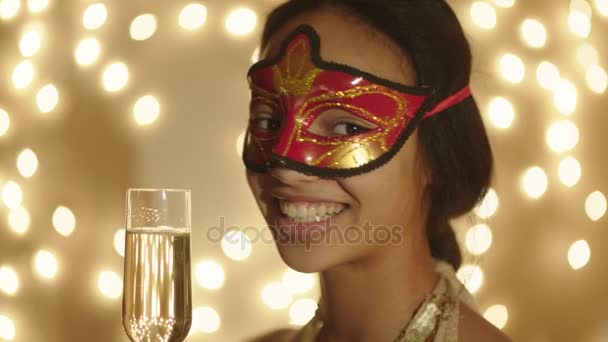 Close up tiro de mulher negra usando máscara de carnaval com taça de champanhe na mão — Vídeo de Stock