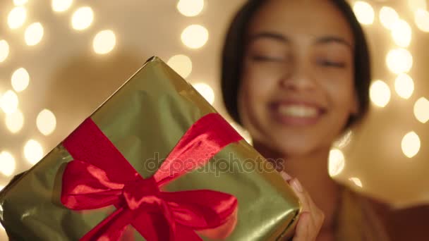 Όμορφη μαύρη γυναίκα κρατώντας μεγάλο δώρο κουτί στα χέρια της και χαμογελά — Αρχείο Βίντεο