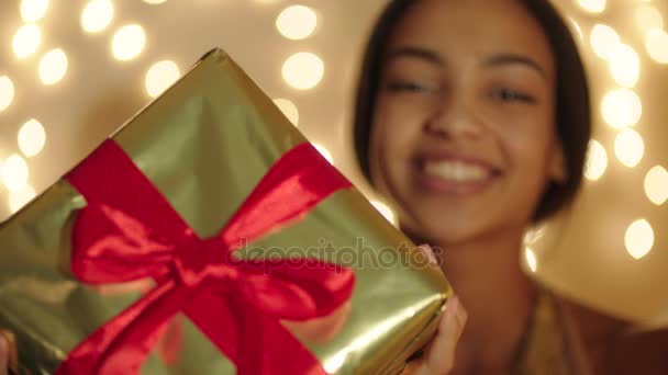 Belle jeune femme gardant une grande boîte cadeau dans ses mains et souriant — Video