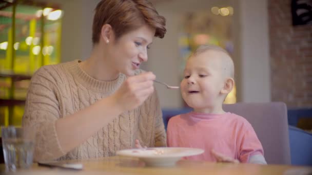 Mother feeds her son with a spoon — Stock Video