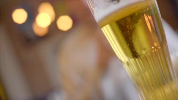 Bierglas met rammelende bril op de achtergrond onscherp — Stockvideo