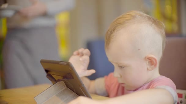 Malý kluk hraje na tabletu a číšník přináší zmrzlina — Stock video