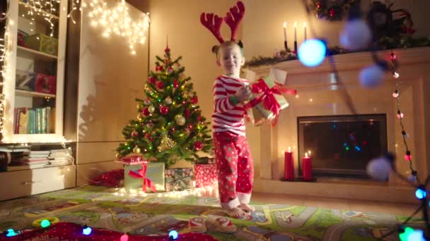 Joyeux garçon avec boîte cadeau le soir du Nouvel An — Video