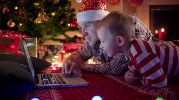 Primer plano de padre e hijo de compras en línea y la elección de regalos para la Navidad — Vídeos de Stock