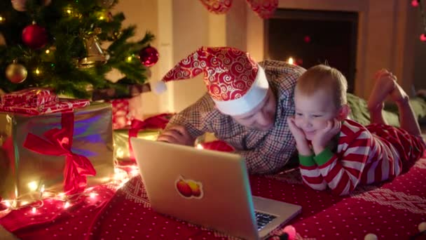 Отец и сын общаются онлайн в канун Рождества — стоковое видео