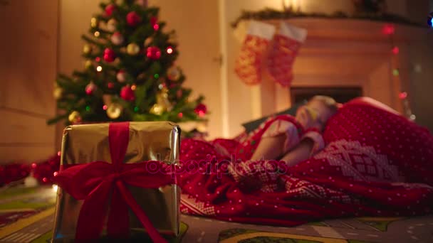 Nahaufnahme einer goldenen Geschenkschachtel und eines kleinen Jungen, der auf das neue Jahr wartet — Stockvideo