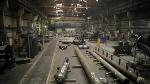 Трубный завод тяжелой промышленности. Металлические трубы и сварщики на заднем плане — стоковое видео