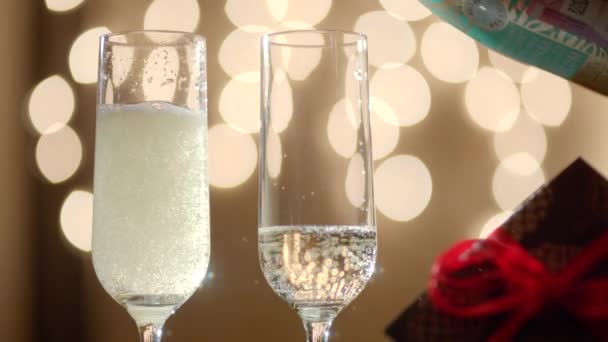 Twee glazen vullen met champagne en gift box — Stockvideo