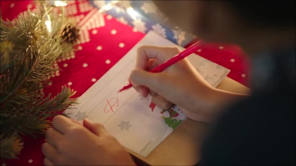 Adolescente chica está mintiendo cerca decorado árbol de Navidad y escribir carta de Navidad a Santa Claus en la víspera de Navidad — Vídeos de Stock