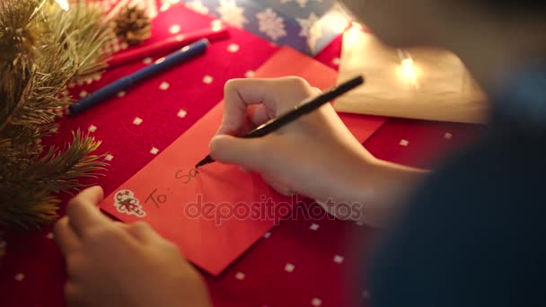 Menina preta colocando uma carta de Natal com lista de desejos no envelope para Papai Noel na véspera de Natal — Vídeo de Stock