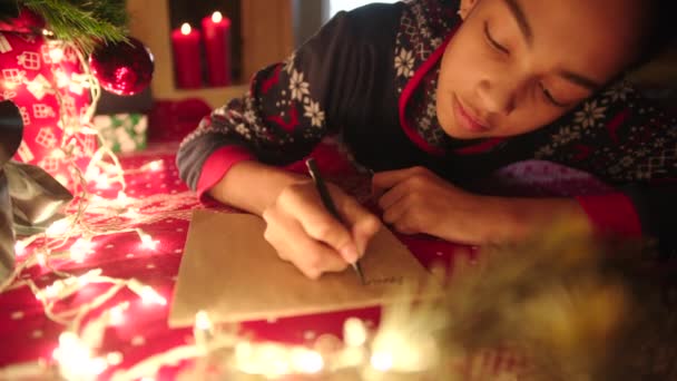 Tiener meisje is liggen in de buurt van versierde kerstboom en Kerstmis brief aan de Kerstman — Stockvideo