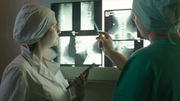 Doctor gives directions to nurse showing x-rays — Stock Video