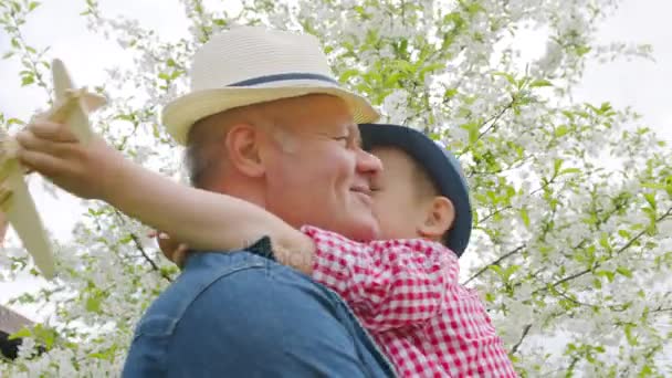 El niño pequeño está abrazando a su abuelo y agradeciéndole por el regalo — Vídeos de Stock